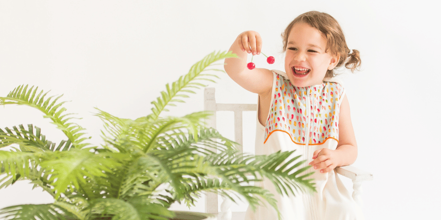 Little girl playing with an indoor plant