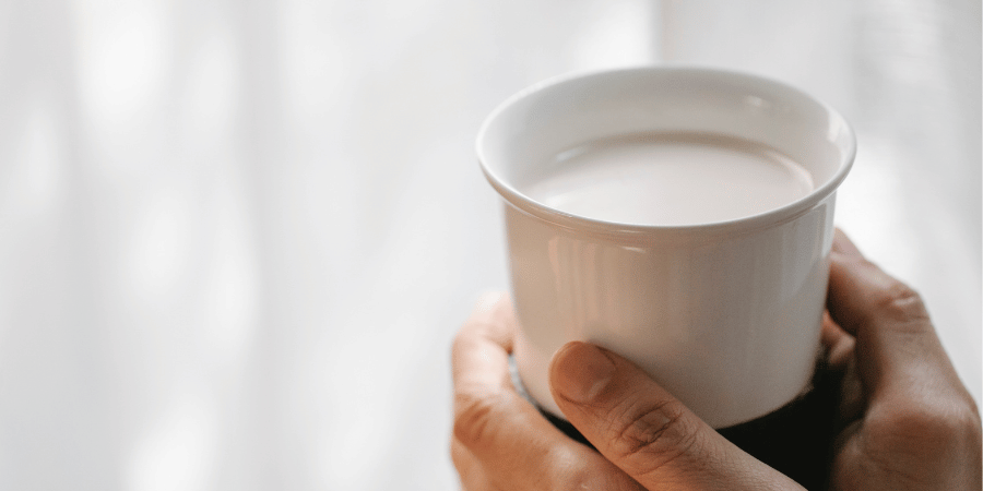 Someone holding a cup of hot milk